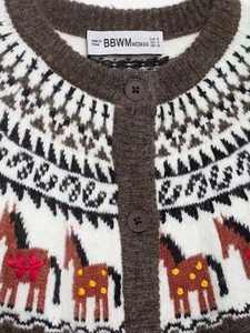 Détail d'un cardigan en maille vintage avec motif de cheval ethnique et texture jacquard