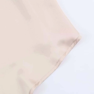 Detailed macro view of the champagne satin fabric hem with clean stitching finish