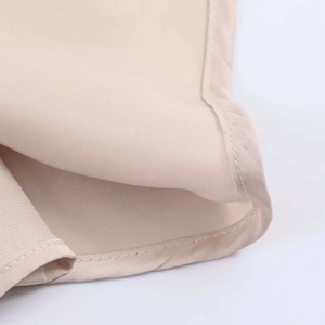 Close-up of champagne satin fabric showing smooth texture and neat stitching details