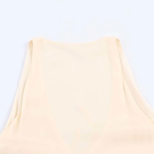 Detailed view of the crew neckline and soft knit texture of the beige sleeveless dress