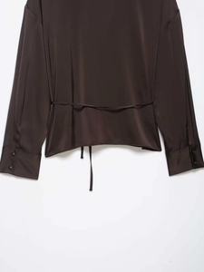 Détail du dos de la chemise en satin marron foncé avec lien à la taille et reflet