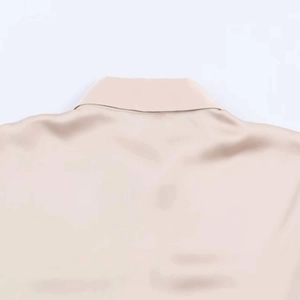Close-up of champagne satin blouse showing silky texture and rear neckline details
