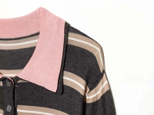 Detail of knit polo shirt collar with pink trim and striped pattern texture