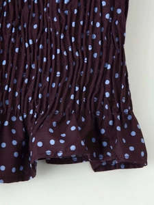 Détail du tissu smocké à pois bleu clair avec une finition à volants sur le bord