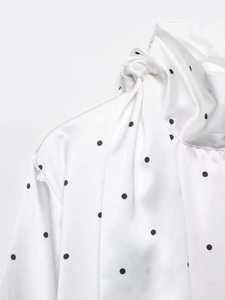 Détail du col à nœud papillon sur une chemise blanche à pois argentés satinés