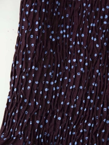 Détail du tissu froncé violet foncé avec un motif de texture à pois bleu clair