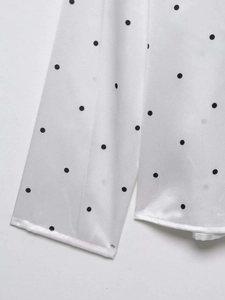 Gros plan détaillé sur un tissu satiné blanc à pois noirs avec éclat soyeux doux