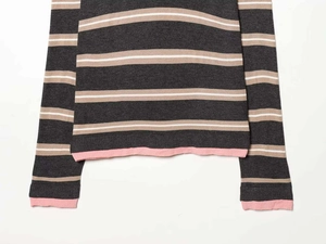 Detail of striped knit sweater showing pink ribbed cuffs and high-quality fabric texture
