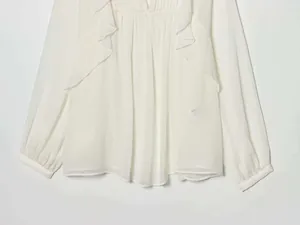 Detail of white chiffon shirt with layered ruffles and elastic cuffs on the sleeves