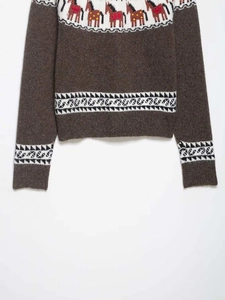Gros plan détaillé du pull en maille marron avec jacquard cheval et motifs nordiques