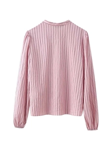Vue détaillée de la texture du tissu à rayures roses et des poignets élastiques de la chemise