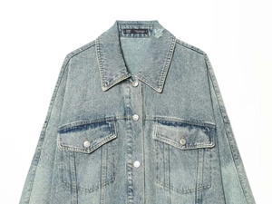 Dettaglio giacca di denim lavaggio chiaro con colletto usurato e tasche a patta