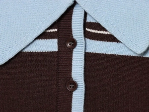 Dettaglio del colletto a polo a contrasto e dell'abbottonatura sul maglione vintage