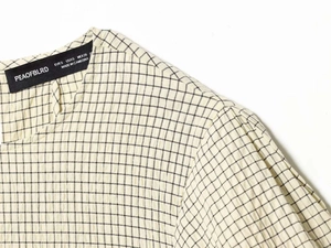 Detail of checkered blouse collar showing high quality sewing and fabric texture
