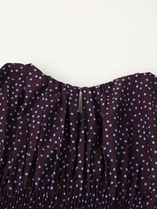 Détail de tissu marron à pois avec ouverture en goutte d'eau et finitions smockées
