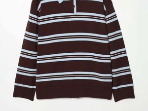 Dettaglio della trama a maglia spessa e polsini a coste del maglione a righe