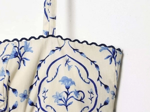 Dettaglio dell'abito a fiori con finiture ric rac blu e cuciture rifinite a mano