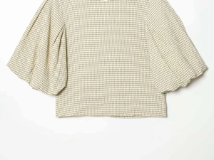 Detail of puff sleeve structure on beige gingham top with refined checkered pattern fabric