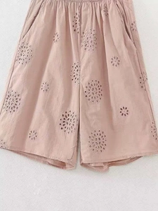 Detail showing pink wide-leg shorts with circular eyelet embroidery and elastic waist