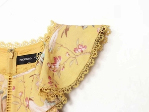 Dettaglio vestito estivo giallo con bordo in pizzo girasole e stampa floreale uccelli