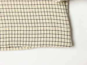 Close-up of seersucker fabric with black grid pattern on cream white background