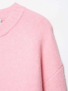 Detail view of pink knit sweater featuring a ribbed crew neck and soft fuzzy texture