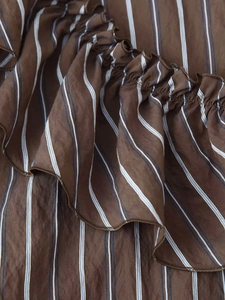 Vue détaillée du tissu rayé marron avec texture à volants et finitions de couture précises
