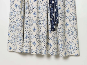 Dettaglio del motivo floreale e cintura a contrasto su un vestito estivo elegante