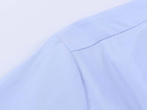 Close-up of high-quality light blue poplin shirt shoulder with reinforced stitching