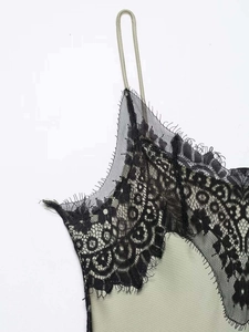 Close-up of olive green dress featuring delicate black eyelash lace trim and thin straps