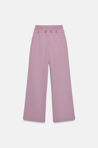 Dettaglio dei pantaloni ampi rosa polvere con vita alta elastica in morbido cotone