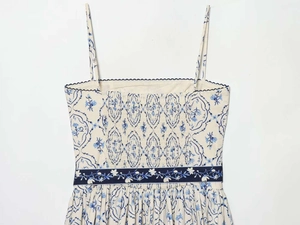 Dettaglio dell'abito floreale con stampe di viti blu e corpetto elasticizzato a nido d'ape