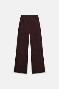 Dettaglio dei pantaloni sportivi marrone scuro a vita alta con gamba larga ed elastico