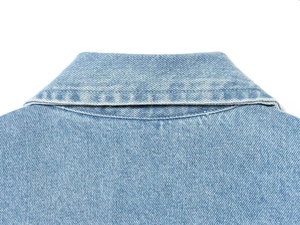 Detailed close-up of collar stitching and washed light blue denim fabric texture