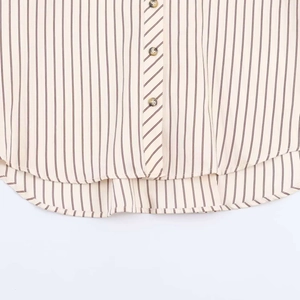 Detalle de camisa a rayas con botones de carey y tapeta con patrón diagonal