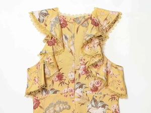 Dettaglio dell'abito estivo giallo a fiori con bordo in pizzo all'uncinetto e zip sul retro