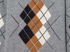 Detailaufnahme des Argyle-Strickmusters am Pullover in Grau, Schwarz und Braun