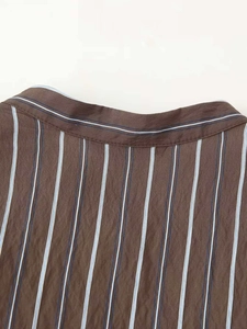 Gros plan du col montant étroit d'une chemise à rayures marron en coton et lin texturé