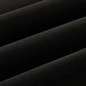 Close-up of black woven fabric texture showing elegant drape and smooth fiber finish
