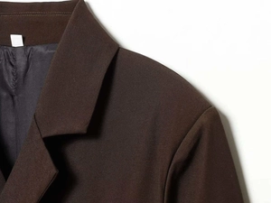 Detailed view of the dark brown suit blazer lapel with fine twill woven fabric texture