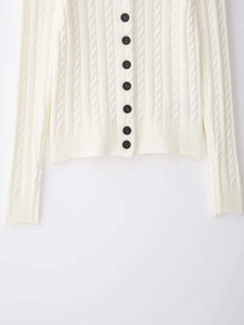 Detail des Zopfmusters und der schwarzen Knöpfe an einem beigen Strickcardigan