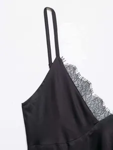 Close-up of black satin camisole with delicate eyelash lace trim and thin straps