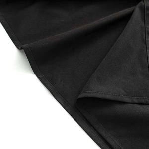 Detail view of the black wrap dress hem with high-quality double stitching and fine texture