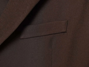 Detailed close-up of premium dark brown twill fabric and refined welt pocket stitching
