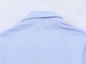 Close-up of a sharp point collar on a light blue poplin shirt with neat stitching detail