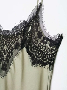 Detail of elegant sage green satin dress with exquisite black eyelash lace at the neckline