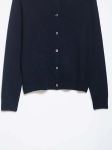 Detailed macro view of dark blue fine knit cardigan with ribbed cuffs and buttons