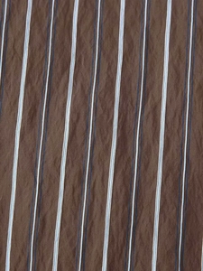 Vue détaillée du tissu rayé marron avec une texture froissée naturelle de la chemise
