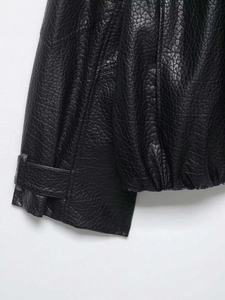 Détail d'un blouson aviateur en similicuir noir montrant les poignets et sangles d'ourlet