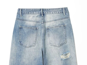 Detail der hellblauen Jeans mit Gesäßtaschen und markanten Distressed-Elementen